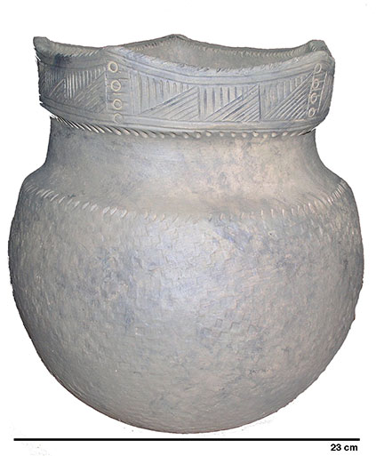 Round ceramic vase with a circumference of approximately 25 cm. The upper part of the pottery incorporates a flattened neck, approximately 6 cm high, It is decorated with oblique hatchings traced in the clay before it is fired and four small carved circles that are arranged in a vertical row. These circles are placed directly beneath each point. 